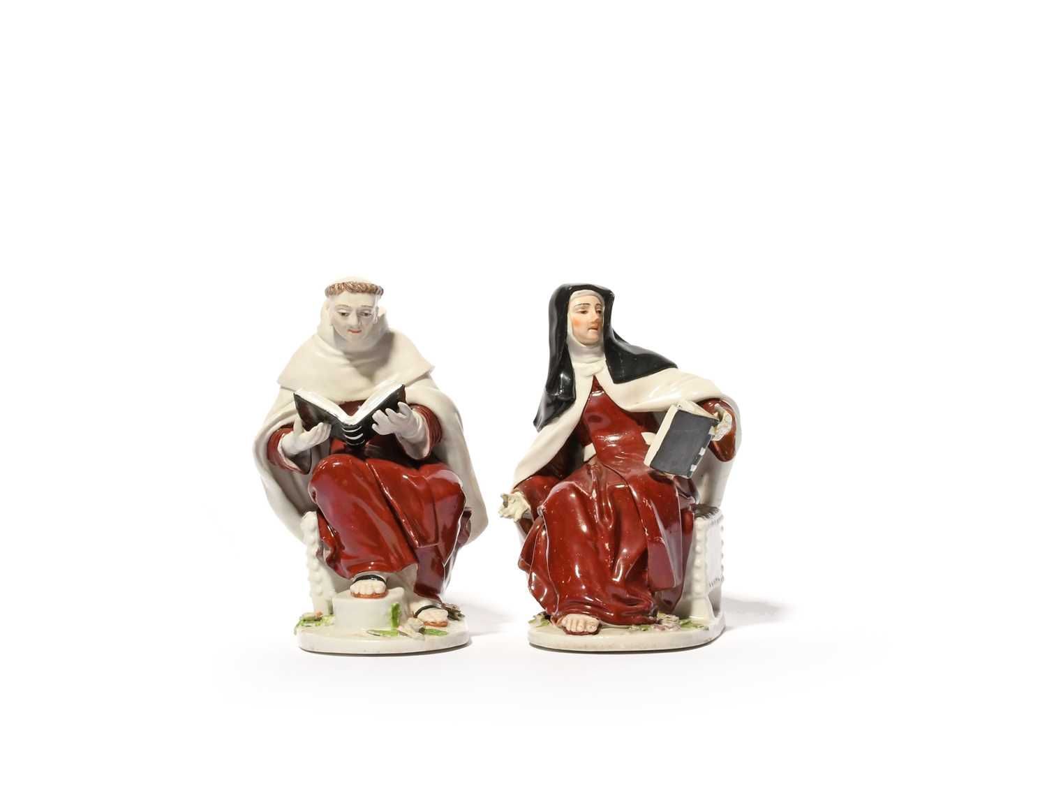 A pair of Chelsea figures of a Nun and a Monk, c.1755, each seated on a studded box and wearing a