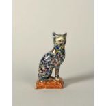 A Scottish pearlware figure of a cat, 19th century, seated on its haunches with head turned to the
