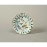 A small delftware plate, c.1720-30, of pancake form, painted in yellow, blue, green and manganese