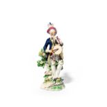 A Bow figure of a musician, c.1760-65, standing before low flowering bocage and playing the