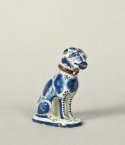 A delftware model of a dog, dated 1760, seated on its haunches on an oval pad base, its head