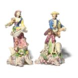 A large pair of Bow figures of a piper and his companion, c.1762-65, he standing with a dog and a