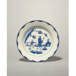 A Bow blue and white plate, c.1758-60, painted with the Golfer and Caddy pattern, a Chinese figure