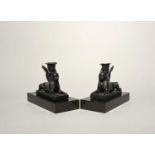 A pair of Wedgwood black basalt sphinx candlesticks, 19th century, each modelled as a recumbent
