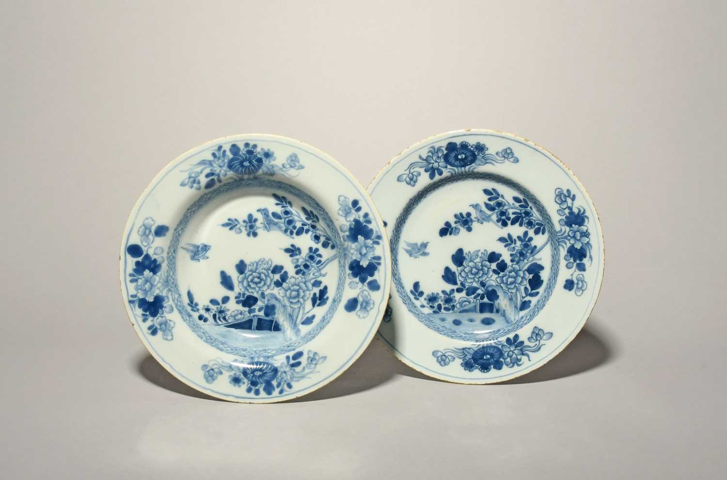 A Dublin delftware plate and a soup plate, c.1750, each painted in blue with two birds above