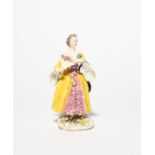 A rare Bow figure of a lady, c.1758, after a Meissen model by Peter Reinicke, wearing a layered