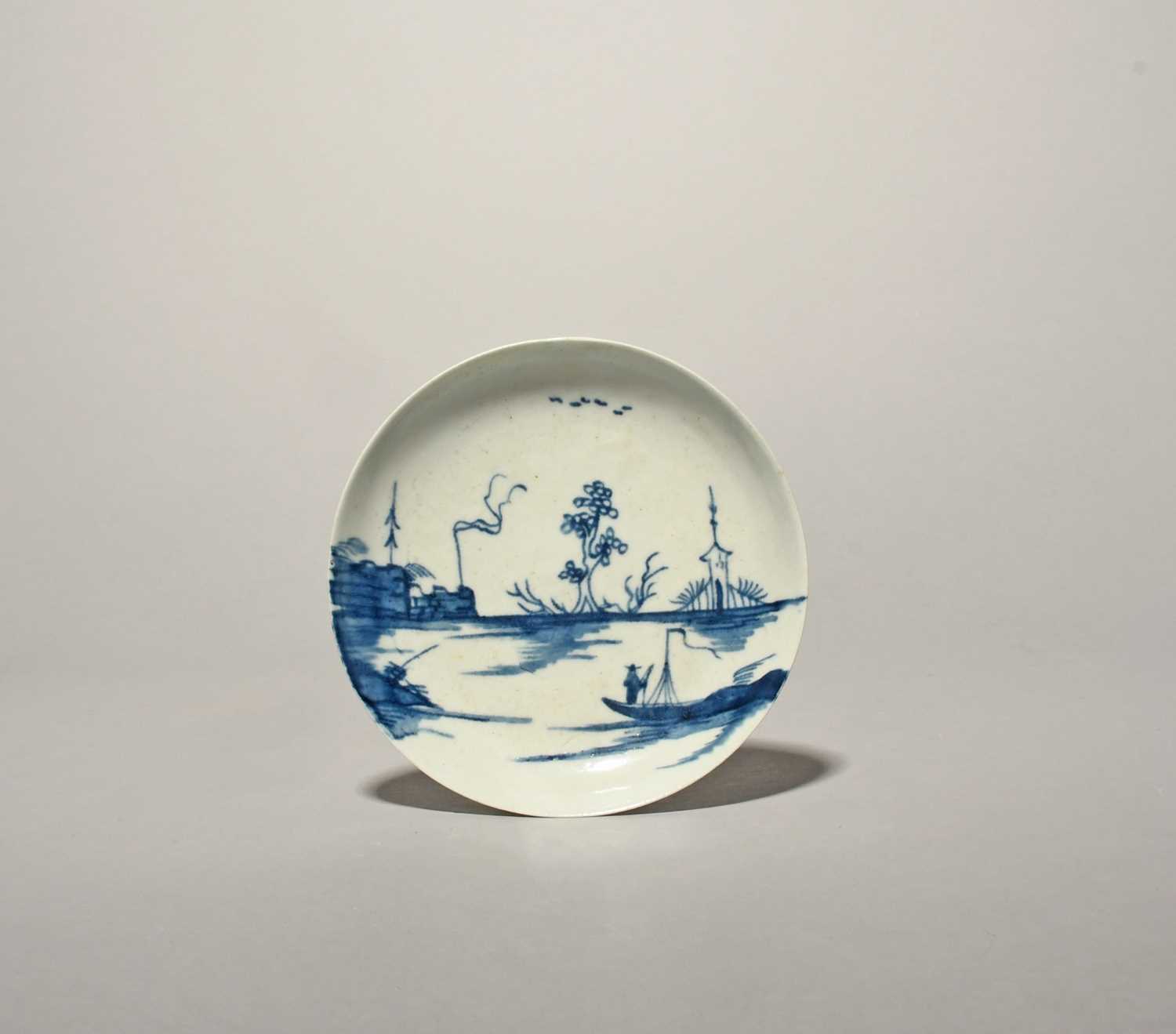 A rare Longton Hall blue and white saucer, c.1755-60, painted with the 'Ruined Castle' pattern, a