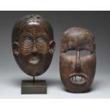 Two East African masksone with incised lines around the eyes and on the chin, with three holes to