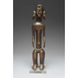 A Mumuye standing female figureNigeriawith an oval face with a triangular nose and pursed lips,