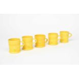 Walter Keeler (born 1942) five mugs, each glazed canary yellow, impressed seal mark to side 9cm.