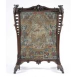 A CARVED WALNUT FIRESCREEN 18TH CENTURY inset with a needlework panel worked with petit and gros