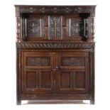A CHARLES II OAK COURT CUPBOARD C.1680 carved with scrolling rondels and flowerheads, with a pair of
