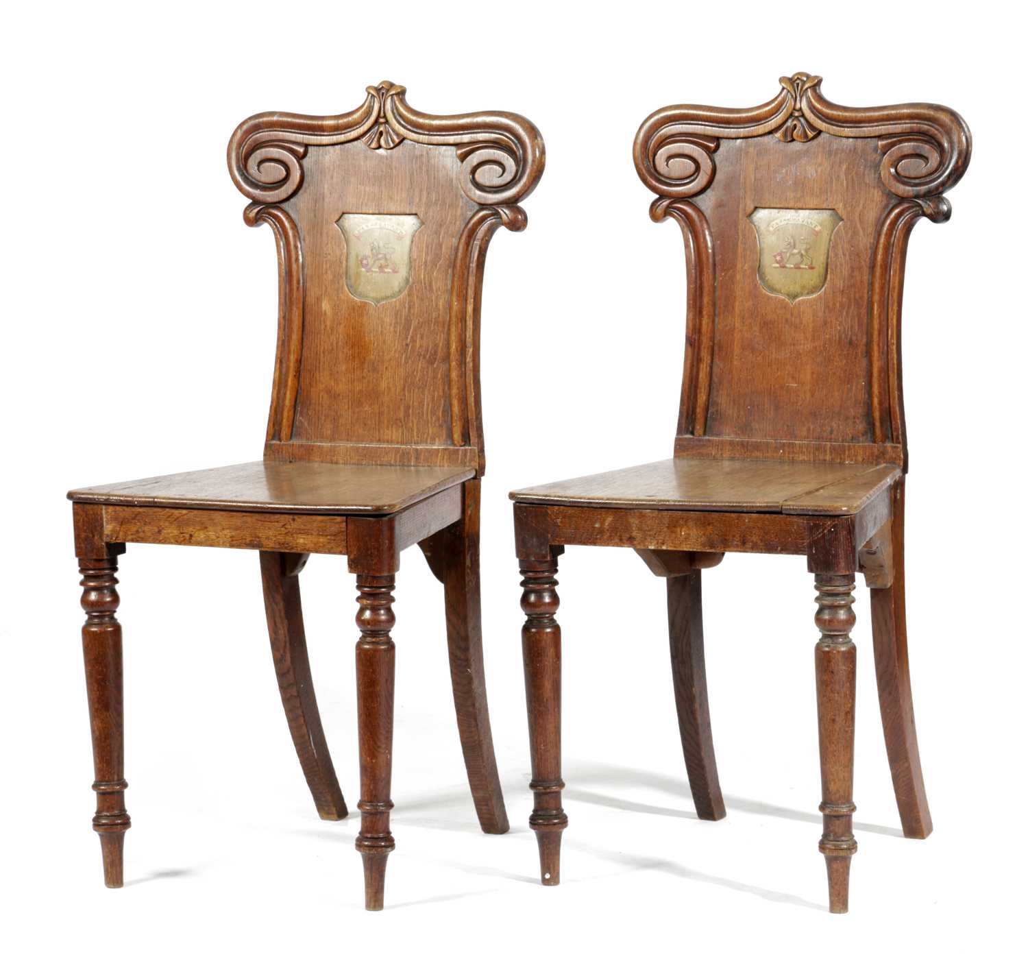 A PAIR OF WILLIAM IV HALL CHAIRS C.1830 each with a scroll carved back and painted with a crest,