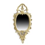 A GEORGE II GILTWOOD WALL MIRROR C.1740-50 the oval plate inside a foliate frame beneath an ogee