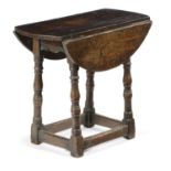 A SMALL OAK DROP-LEAF TABLE IN 17TH CENTURY STYLE the oval top on turned legs, united by