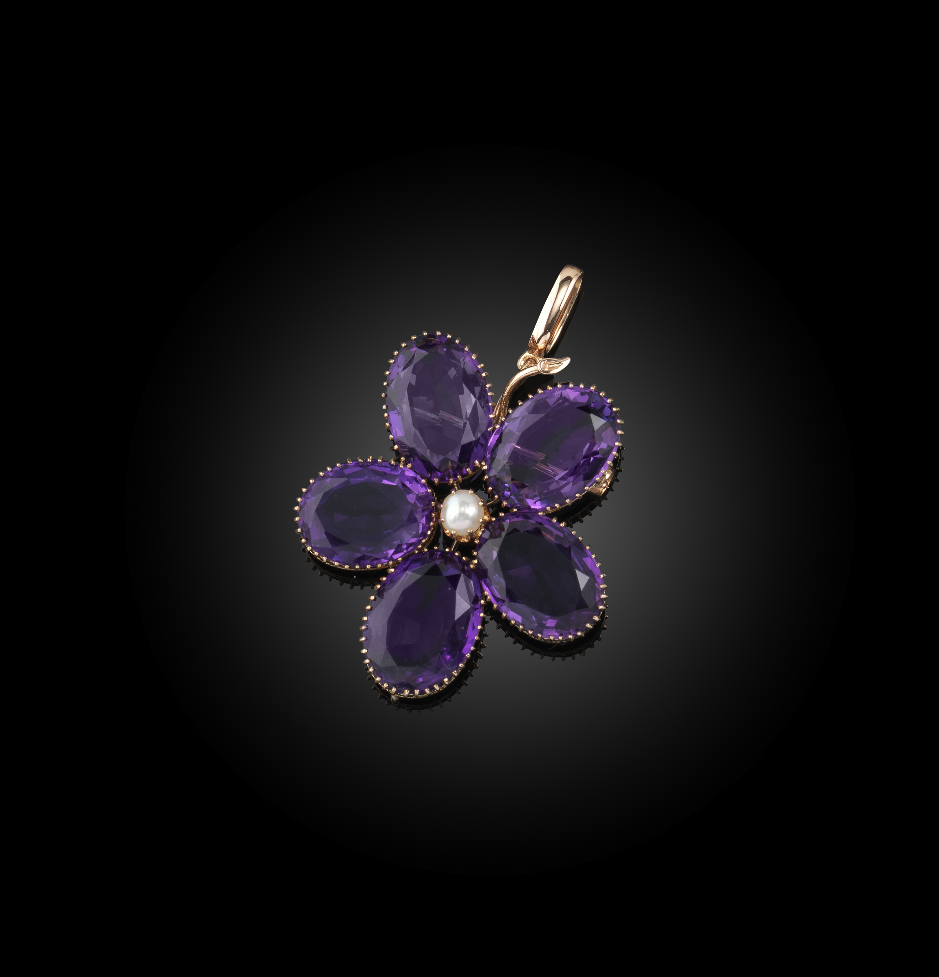 An early 20th century amethyst flower brooch / pendant, set with five matched oval amethysts