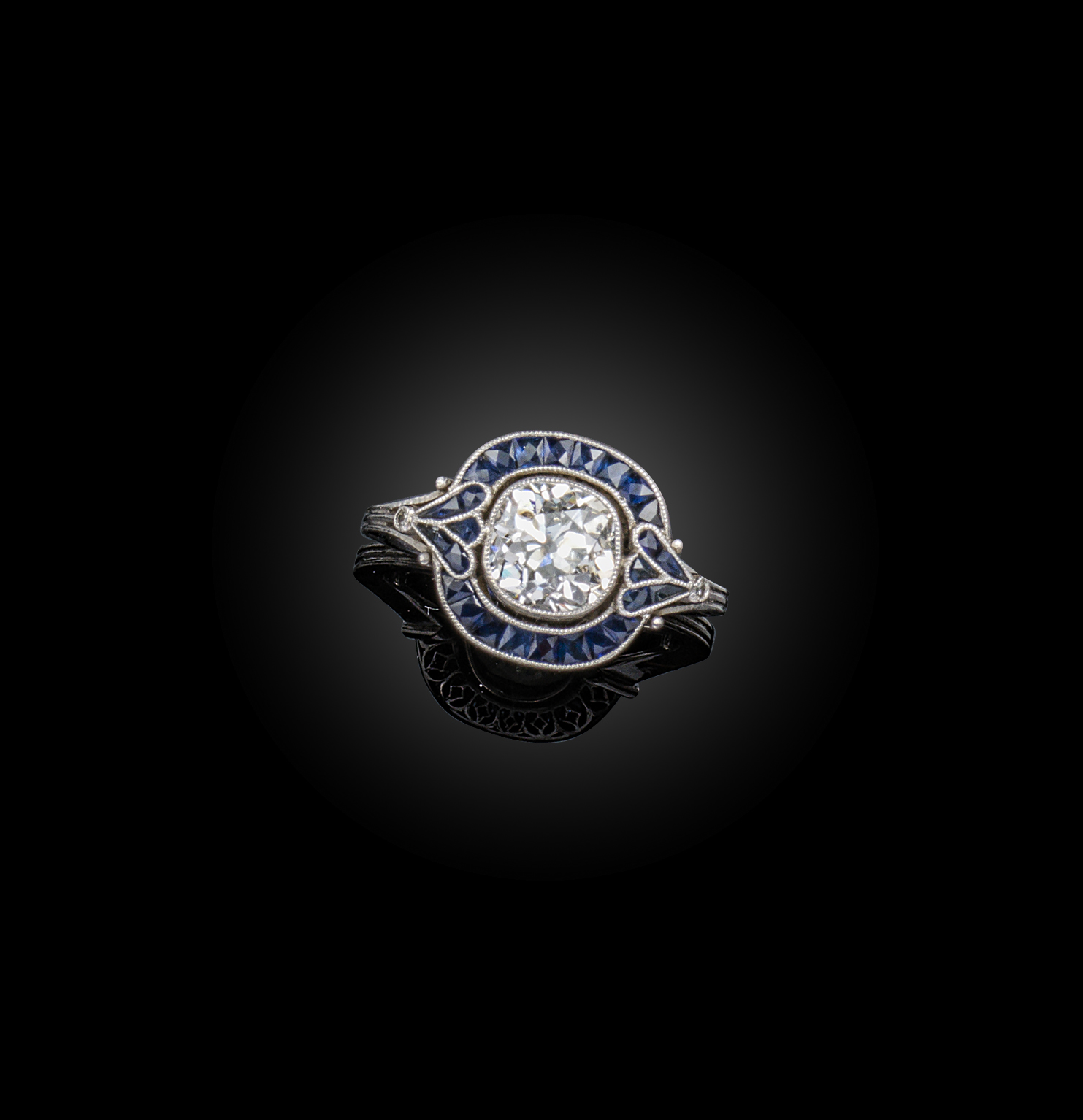 An Art Deco diamond cluster ring, set with a cushion-shaped diamond within a border of French-cut