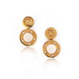 A pair of gold and diamond earrings, each composed of a disc inscribed with stylised letters,