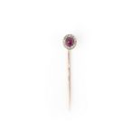 A ruby and diamond stick pin, early 20th century, set with a cabochon ruby within a millegrain-