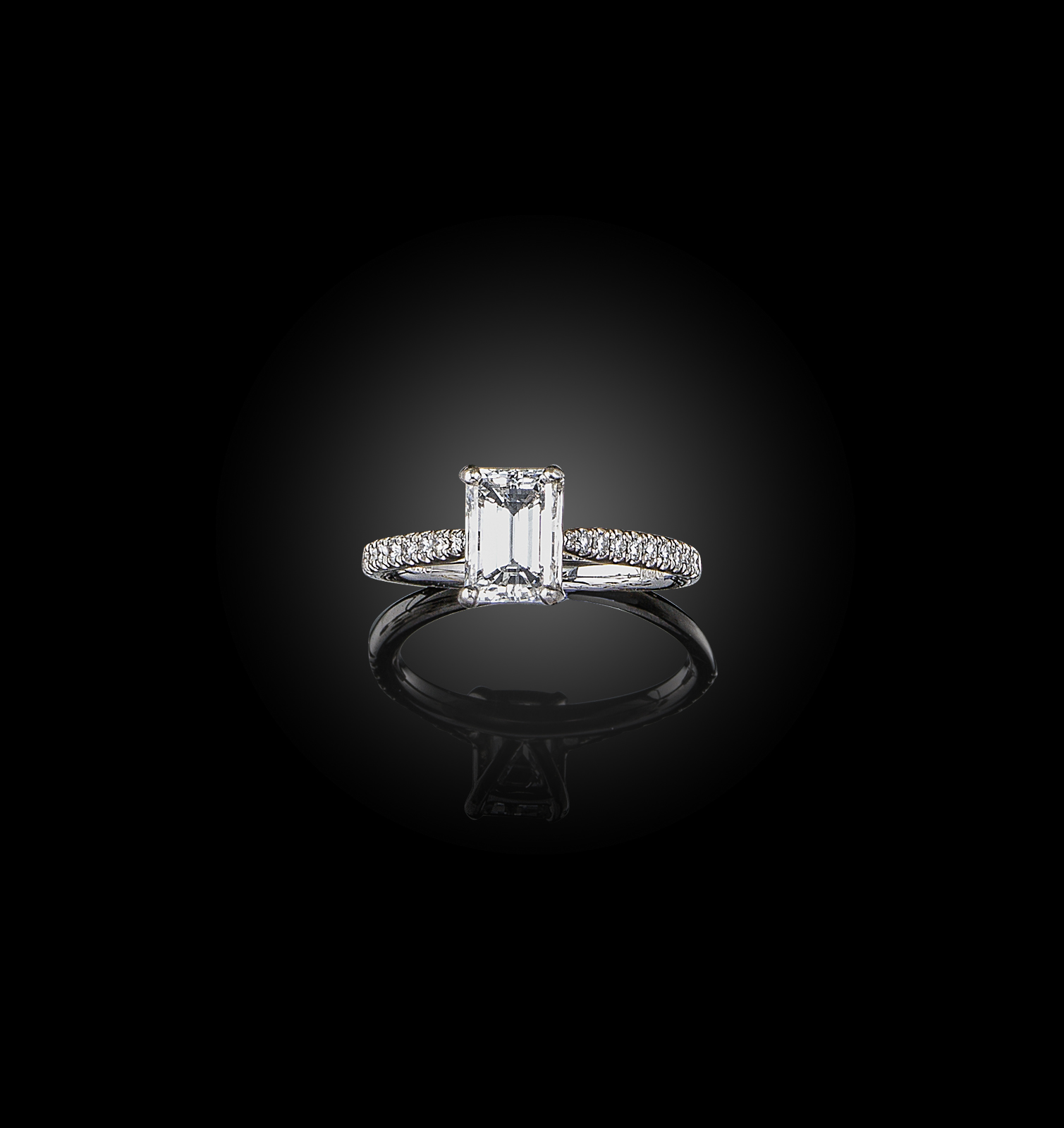 A diamond solitaire ring, the emerald-cut diamond weighing 1.28cts, with diamond-set shoulders in