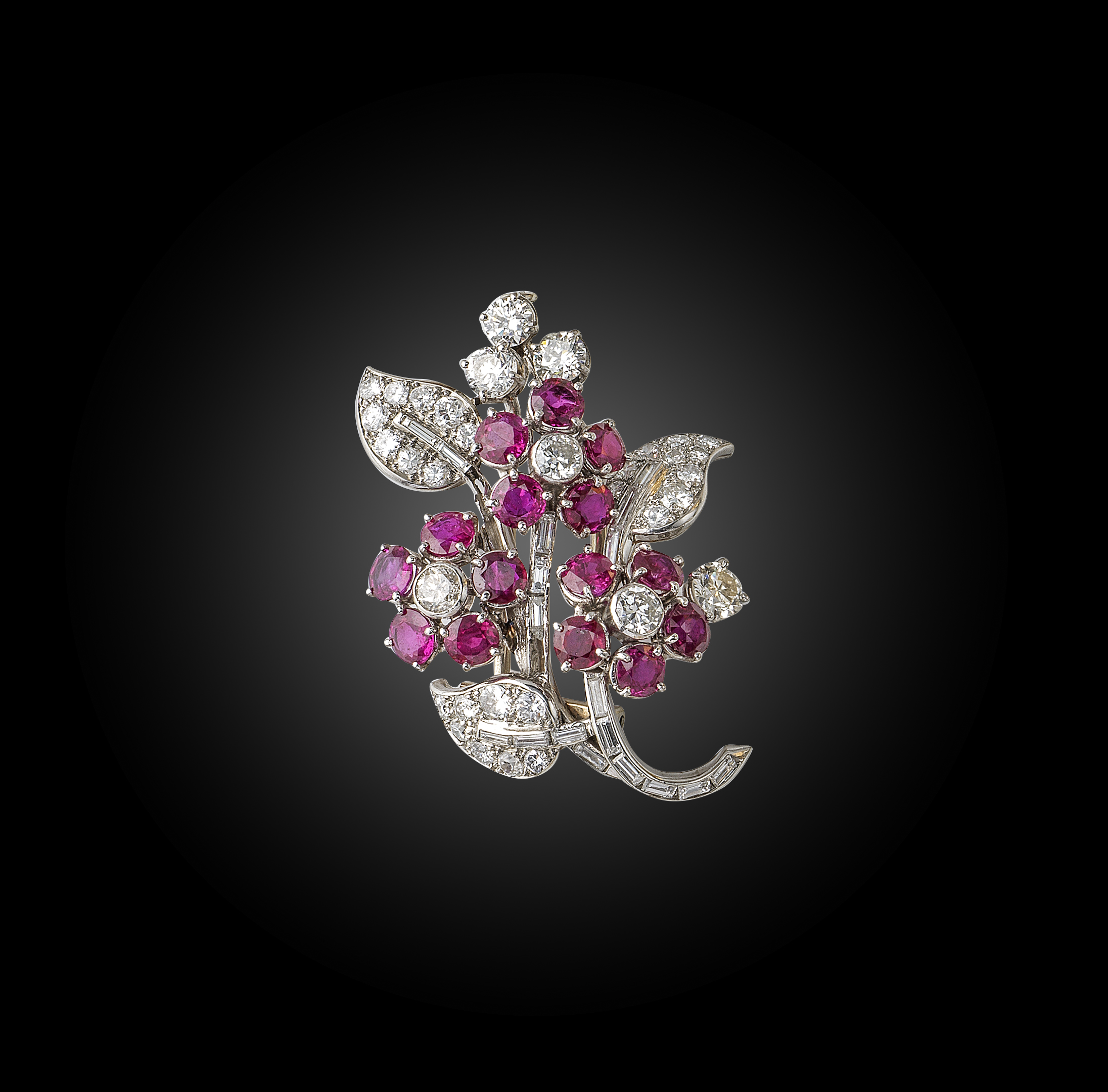 A ruby and diamond brooch, France, circa 1950, designed as a spray of flowers, set with circular-cut