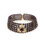 A garnet and diamond choker necklace, centring on a triangular garnet within a border of brilliant-