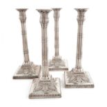 A set of four George III silver candlesticks, probably by John Carter, London 1772, fluted