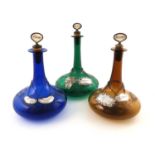 Three 19th century coloured glass decanters,tapering circular ship decanter form, engraved with