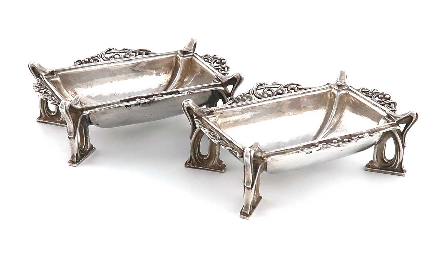 By Omar Ramsden, a matched pair of Arts and Crafts silver salt cellars,London 1931 and 1932, one