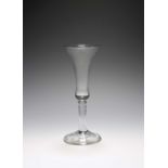 An ale glass, c.1740, with slender bell bowl raised on a plain stem over a folded conical foot,