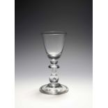 A large baluster wine glass, c.1710-20, the round funnel bowl with a solid base, raised on a ball