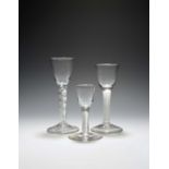Two wine glasses and a cordial glass, c.1750-60, with round funnel bowls, two raised on airtwist