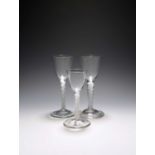 Three wine glasses, c.1750-60, with round funnel bowls raised on differing multi-series opaque twist