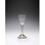 A wine glass, c.1740, the base of the round funnel bowl with hammered decoration, raised on an