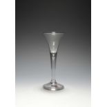 A small wine glass, c.1730, the drawn trumpet bowl raised on a slender plain stem enclosing a single