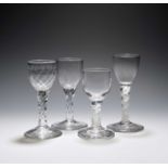 Four small wine or dram glasses, c.1760-80, with round funnel or ogee bowls, two raised on multi-