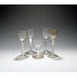 Four small wine glasses, c.1750-70, one with a round funnel bowl engraved with a flower spray on a