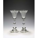 A pair of armorial balustroid wine glasses, c.1750, the bell shaped bowls with a fine band of