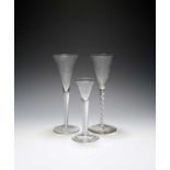 Two toasting glasses or wine flutes, c.1750, with drawn trumpet bowls, one on a cable airtwist stem,