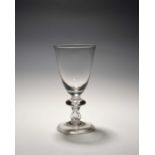 A large baluster glass goblet, c.1710, the deep round funnel bowl raised on a baluster stem with