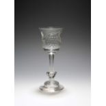 An unusual wine glass, c.1730, the tulip bowl engraved with a butterfly and a large bunch of