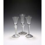 Three wine glasses, c.1750, with bell bowls, one raised on an airtwist stem extending into the