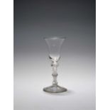 A wine glass, c.1760, with a bell bowl raised on a triple-knopped stem enclosing a multi-series