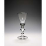A baluster wine glass, c.1710, with conical bowl rising from an acorn knop over a bladed knop and