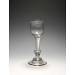 A composite stem wine glass, c.1730-40, with a tulip bowl raised on a composite stem including an