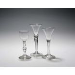 Three wine glasses, c.1750-80, one with a slender bell bowl raised on a square moulded stem