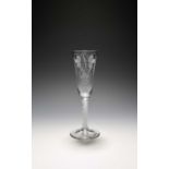 An ale glass, c.1765, the slender funnel bowl engraved with crossed stems of barley and a spray of