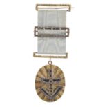 Freemasonry: a gilt-metal symbolic jewel, oval form 40mm, applied level and square with flower-cut
