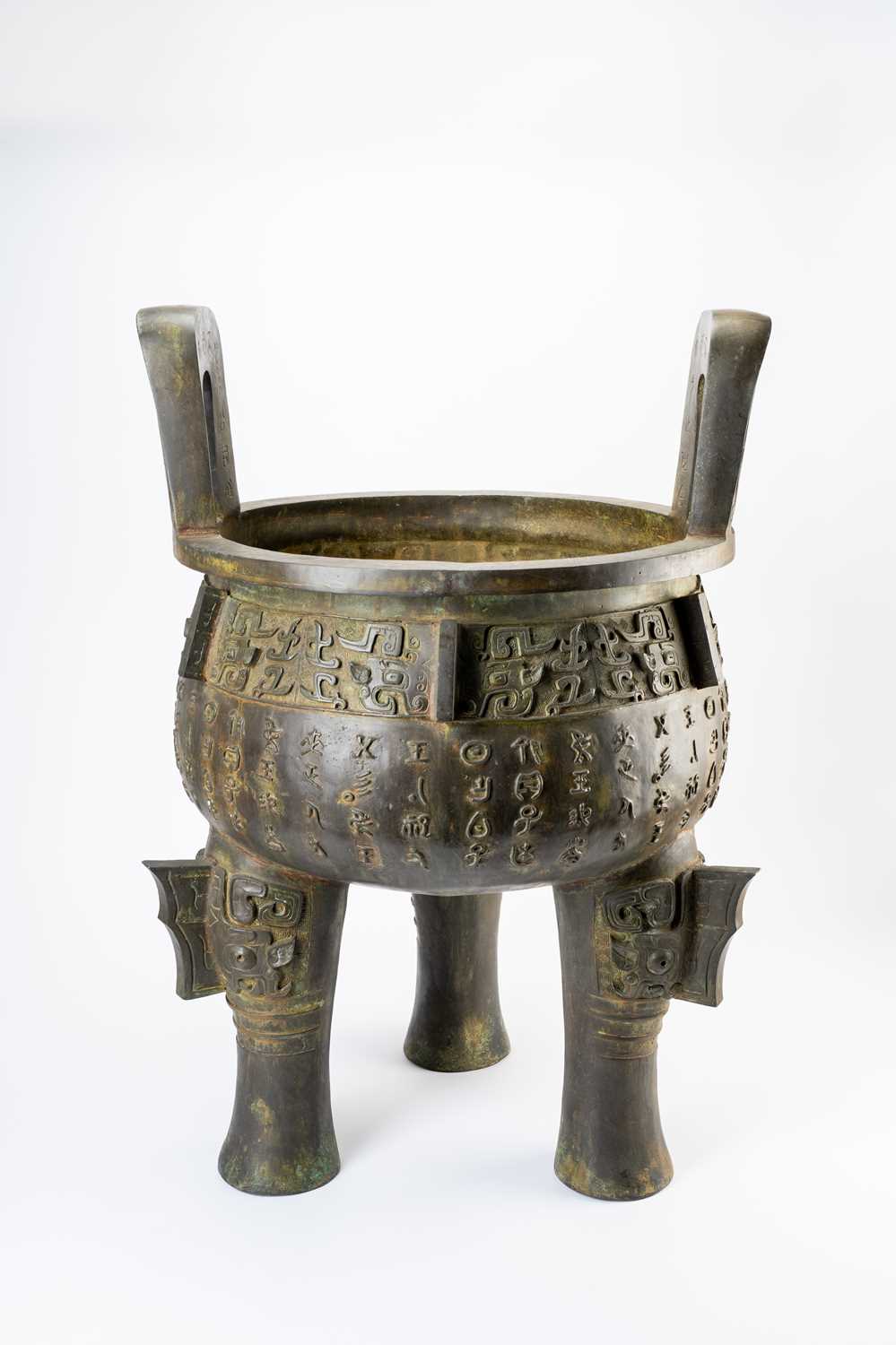 A MASSIVE CHINESE BRONZE ARCHAISTIC DINGMODERNAfter a Zhou dynasty original, the rounded bowl cast