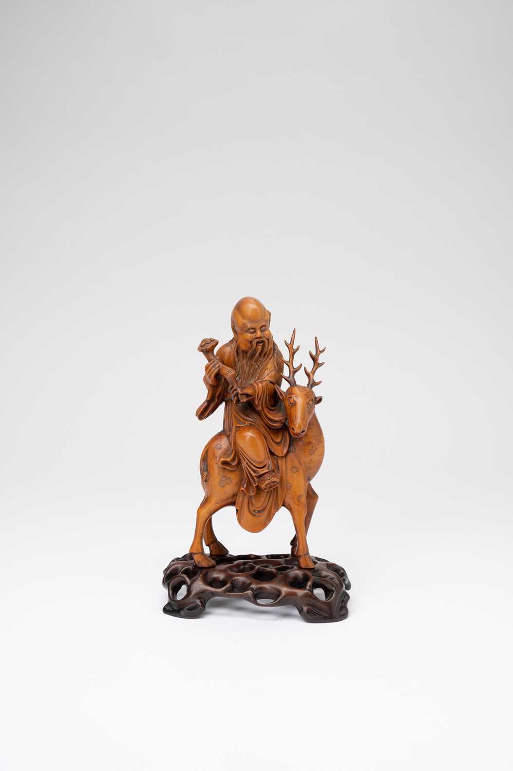 A CHINESE BOXWOOD CARVING OF SHOULAO RIDING A SPOTTY DEERLATE QING DYNASTYThe God sits wearing